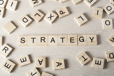 Ahşap blok üzerine yazılmış strateji kelimesi. Ahşap abc