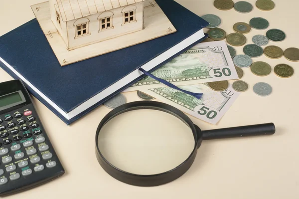 Ahorro en el hogar, concepto de presupuesto. Casa modelo, bloc de notas, pluma, calculadora y monedas en mesa de escritorio de oficina de madera . — Foto de Stock