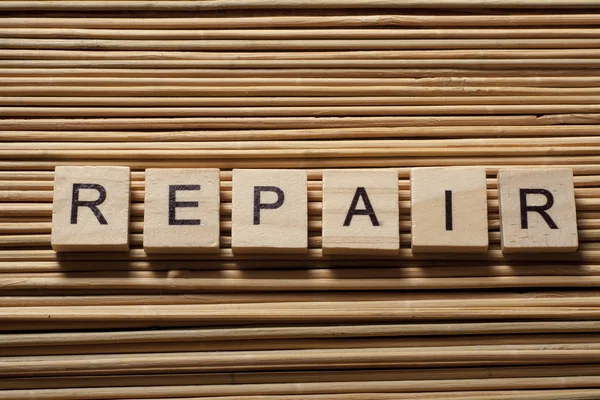 Texto de REPARACIÓN sobre madera abc cubos en fondo de madera — Foto de Stock