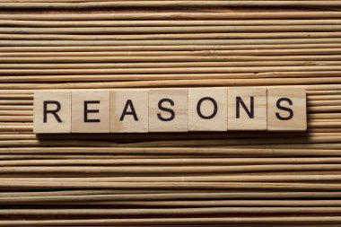 Tahta arka planda ahşap bloğa yazılmış nedenler