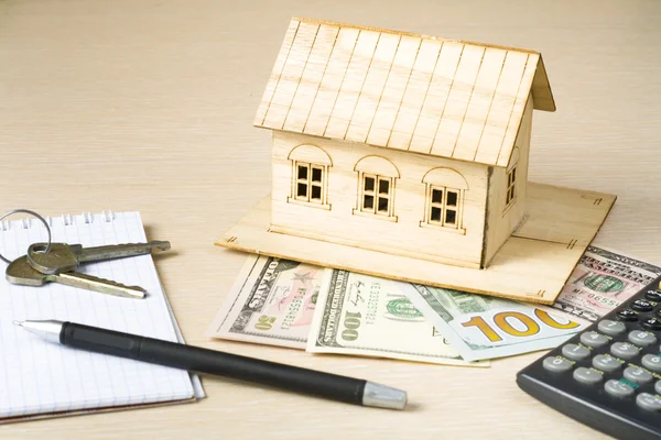 Strona główna oszczędności, koncepcja budżetu. Modelu dom, pióra, kalkulator i monety na stół drewniany office. — Zdjęcie stockowe