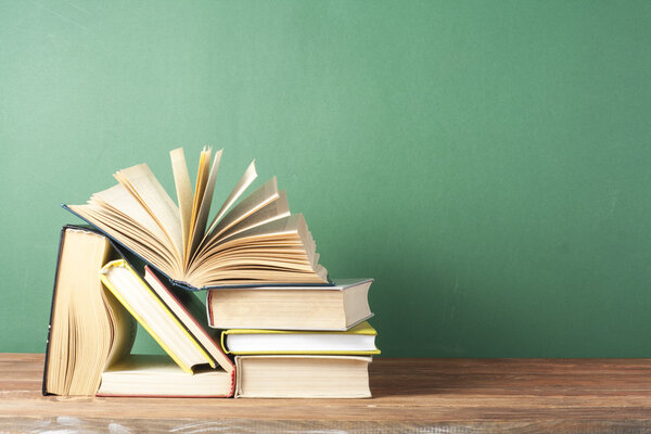 Open book, hardback books on wooden table. Education background. Back to school. Copy space for text.