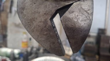 Siyah arka planda bıçak olan metal bir plaka.