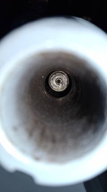 Siyah arka planda beyaz fincanda kahve çekirdekleri.