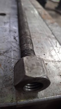 Tahta bir masanın üzerindeki metal borunun yanına.