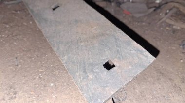 Bir sürü odunu olan paslı metal bir boru.