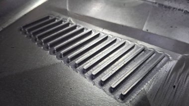 Siyah arkaplan ve levha desenli metal plaka.