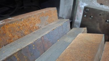 Masanın üzerinde eski paslı demir var.