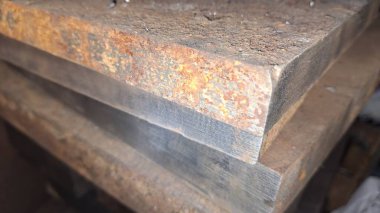 Masanın üzerinde eski paslı demir var.