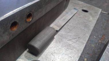 Masanın üzerinde metal saplı metal plaka.