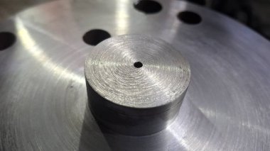 Büyük metal bir borudan siyah saplı metal plaka.