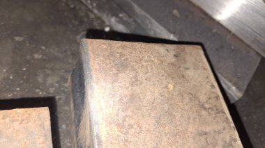 Bir sürü odunu olan paslı metal bir boru.