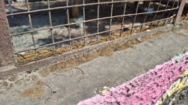 Değişik boyutlarda paslı metal çitler.