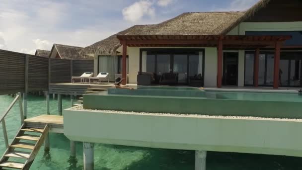 Женщина отдыхает в бассейне на Мальдивах — стоковое видео