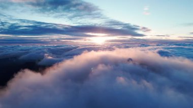 Sonsuz bulut denizinin üzerinde gün doğumu, gökyüzü fotoğrafçısının çerçeveleri dalgalanan bulutlar ve geniş mavi gökyüzü üzerinde sıcak güneş parlıyor.,