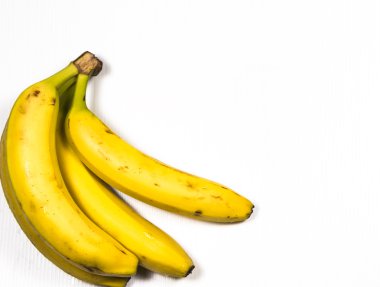 Beyaz arka planda dört sarı olgun muz