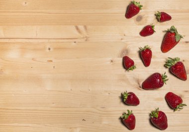 Olgun sulu çilek ahşap bir masa üzerinde. Kırmızı taze çilek arka plan. Zengin yaz çilek bitkileri, organik tarım