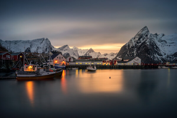 Hamnoy village rorbu and boats with mountains in backround at sunset, Lofoten