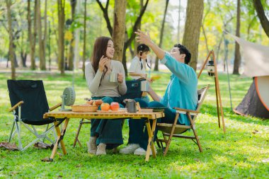 Mutlu Asyalı aile yaz tatilinde parkta piknik yapıyor. Çocuk anne ve babasıyla birlikte parkta gezinin tadını çıkarıyor. Güzel doğa..