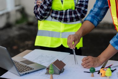 Mimarlar, dizüstü bilgisayarlar ve takım üyeleri inşaat stratejileri, proje planlama veya inşaat planları hakkında görüşmek üzere bir araya gelecekler.