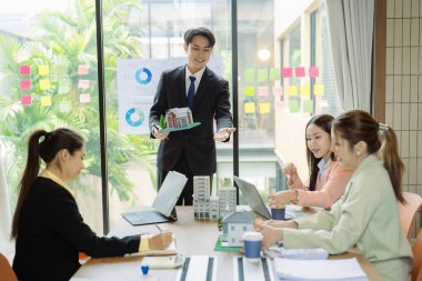 Şirket işletme ekibi potansiyel ev satışları projeleriyle tanışıyor ve karar vermeden önce onlara model evleri gösterip alıcılara teklifler sunuyor..