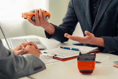 Sigorta acentesi, sözleşmeyi imzaladıktan sonra araba modellerini müşterilere sunar. Araba kiralama konsepti. Komisyoncu sunar ve müşterilere sözleşme imzalamaya karar vermelerini tavsiye eder..