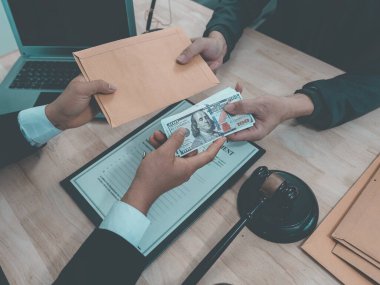 Avukatların kontrat belgeleri ve çekiçle ahşap masada müşterilerden para aldığına dair üst düzey bir görüş.