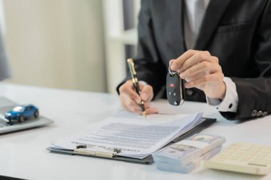 İş adamı, dizüstü bilgisayarı ve tasarruf hesabıyla araba satışlarına yapılan yatırımı analiz ediyor. Yıllık araba vergisi konsepti. Vergi ve krediyle yeni araba almak.