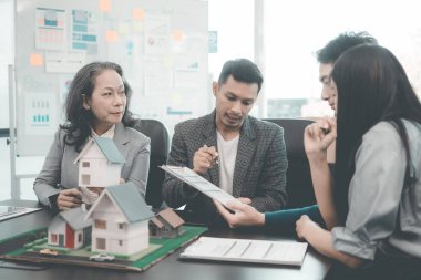 Bir grup Asyalı genç iş adamı emlak projesi için bir ofiste buluşuyorlar. Bir grup zarif, profesyonel giyimli birey küçük bir ev modelini değerlendiriyor..