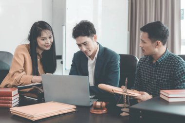 Yasal belgeleri tartışan ciddi bir avukat ciddi bir istişare sırasında, adaletin niteliği olan çekiç ve pullarla önemli belgeleri inceleyecektir..