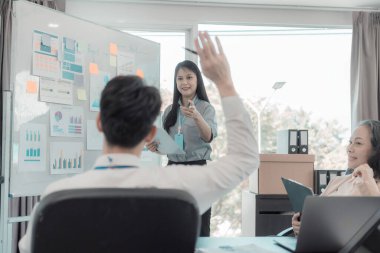 Bir grup iş adamı çalışma masalarında birlikte çalışan ve belgeleri tartışan çalışma arkadaşlarının sonuçlarını gösteren çizelge ve grafikleri tartışıyor..