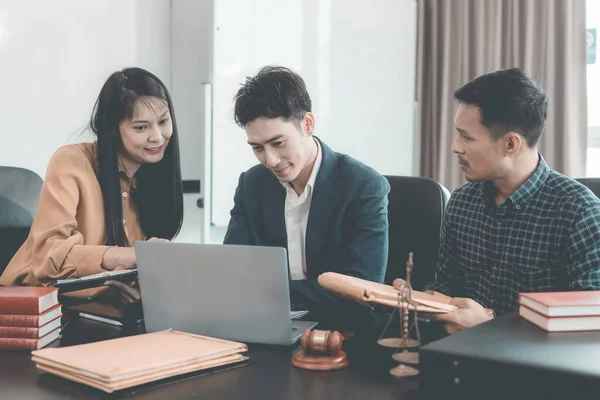 Yasal belgeleri tartışan ciddi bir avukat ciddi bir istişare sırasında, adaletin niteliği olan çekiç ve pullarla önemli belgeleri inceleyecektir..
