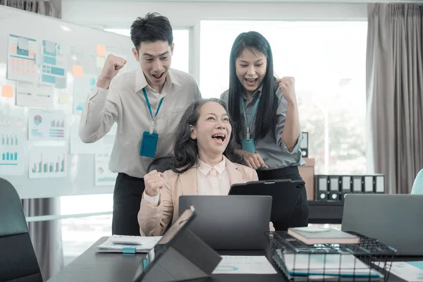 Bir grup başarılı Asyalı iş adamı gülümseyip gülüyor, poz veriyor ve bir şirket ofisindeki konferans salonunda neşe jestleri yapıyor..