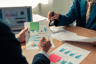 Business people discussing charts and graphs showing results of teamwork in a meeting to analyze financial reports, planning strategies, success.