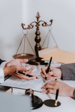 A notary or notary working with contract documents in a courtroom, meeting with clients, and discussing real estate contract documents.