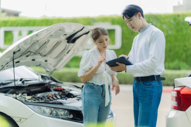 Trafik kazası, sigorta acentesi yol kenarındaki kazadan sonra hasarlı araç ve müşteri tabelalarını inceliyor..
