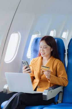 Cep telefonları ve kredi kartları kullanarak, nakitsiz ödemeler yaparak, uçaklardaki kadınlar, uçak pencereleri, seyahatin heyecanını ve beklentilerini yakalayarak,.