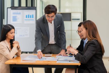 Bir grup iş adamı ofis konferans odasında iş planını tartışıyor. Proje planlaması, yaratıcı beyin fırtınası, fikirleri tartışmak, belgeler kullanmak, dijital cihazlar.