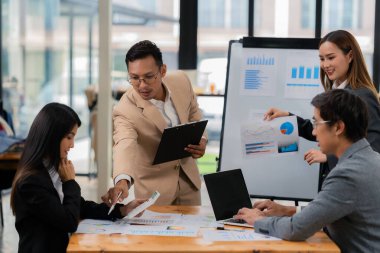 Bir grup iş adamı ofis konferans odasında iş planını tartışıyor. Proje planlaması, yaratıcı beyin fırtınası, fikirleri tartışmak, belgeler kullanmak, dijital cihazlar.