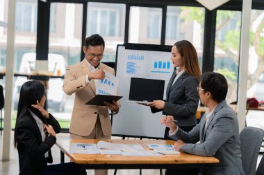 Bir grup iş adamı ofis konferans odasında iş planını tartışıyor. Proje planlaması, yaratıcı beyin fırtınası, fikirleri tartışmak, belgeler kullanmak, dijital cihazlar.