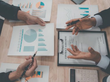 İş ve yatırım kavramları: İş adamları başarılı takım çalışmalarının sonuçlarını gösteren grafikler ve grafikleri tartışıyorlar (yakın plan görünüm).