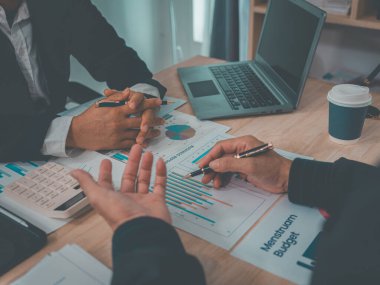 İş dünyası ekibi başarılı takım çalışmalarının, finansal konseptlerin ve yakın çekim çekimlerinin sonuçlarını gösteren çizelge ve grafikleri tartışıyor..