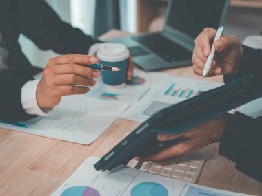 İş dünyası ekibi başarılı takım çalışmalarının, finansal konseptlerin ve yakın çekim çekimlerinin sonuçlarını gösteren çizelge ve grafikleri tartışıyor..