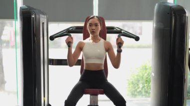 Asyalı kadınların spor salonunda egzersiz yaparken, sağlık ve sağlıklı bir yaşam tarzını desteklerken, eğitim, refah ve spor yaparken çekilmiş fotoğrafları..