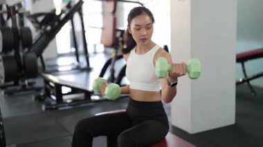 Asyalı kadınların spor salonunda egzersiz yaparken, sağlık ve sağlıklı bir yaşam tarzını desteklerken, eğitim, refah ve spor yaparken çekilmiş fotoğrafları..