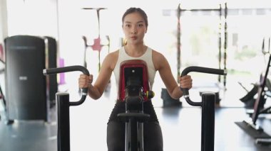 Asyalı kadınların spor salonunda egzersiz yaparken, sağlık ve sağlıklı bir yaşam tarzını desteklerken, eğitim, refah ve spor yaparken çekilmiş fotoğrafları..