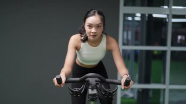 Asyalı kadınların spor salonunda egzersiz yaparken, sağlık ve sağlıklı bir yaşam tarzını desteklerken, eğitim, refah ve spor yaparken çekilmiş fotoğrafları..