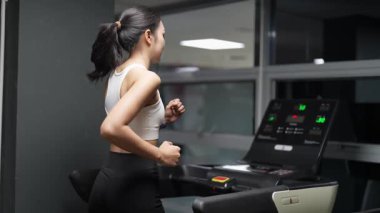 Asyalı kadınların spor salonunda egzersiz yaparken, sağlık ve sağlıklı bir yaşam tarzını desteklerken, eğitim, refah ve spor yaparken çekilmiş fotoğrafları..