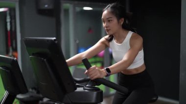 Asyalı kadınların spor salonunda egzersiz yaparken, sağlık ve sağlıklı bir yaşam tarzını desteklerken, eğitim, refah ve spor yaparken çekilmiş fotoğrafları..