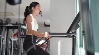 Asyalı kadınların spor salonunda egzersiz yaparken, sağlık ve sağlıklı bir yaşam tarzını desteklerken, eğitim, refah ve spor yaparken çekilmiş fotoğrafları..